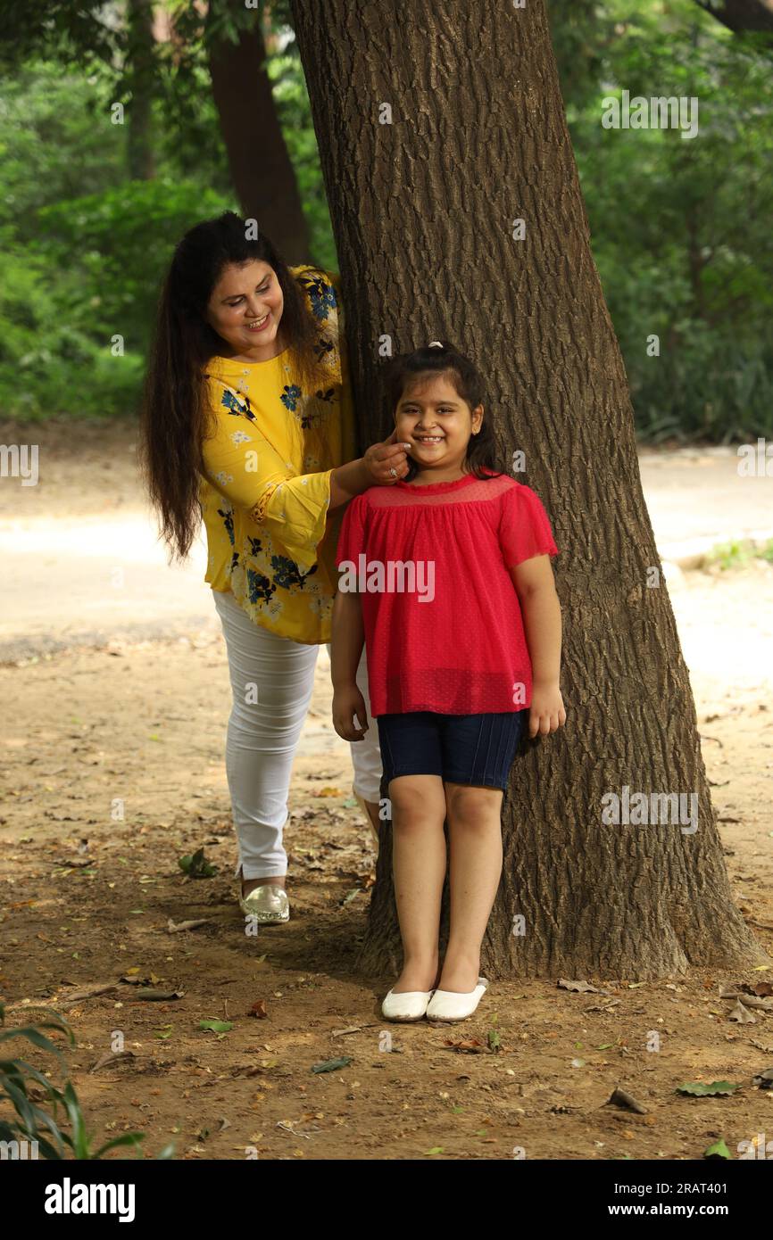 Happy mother and daughter enjoying their time together in a public park. single mother playing with her daughter in green and clean atmosphere. Stock Photo
