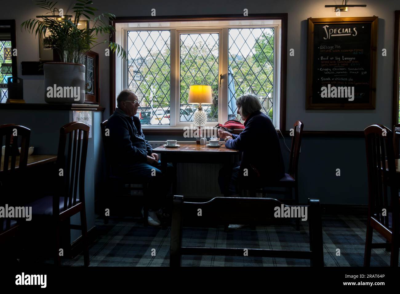 Couple sat at window table having cups of coffee, Wildings Tea Room, Pateley Bridge, Nidderdale, North Yorkshire, England, UK Stock Photo