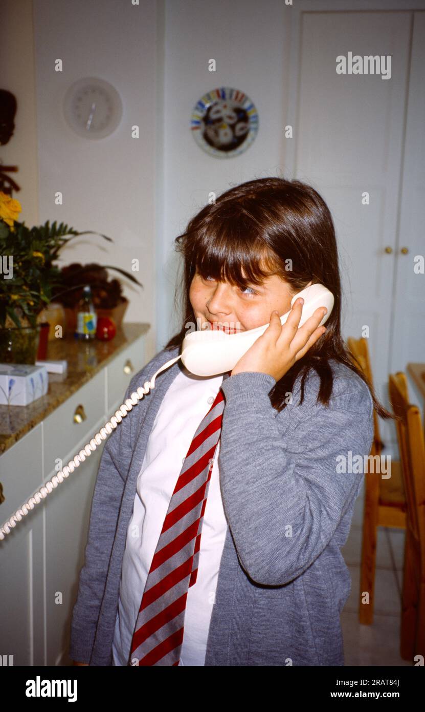 Young Girl Aged 9 Speaking on Landline Telephone Surrey England Stock Photo