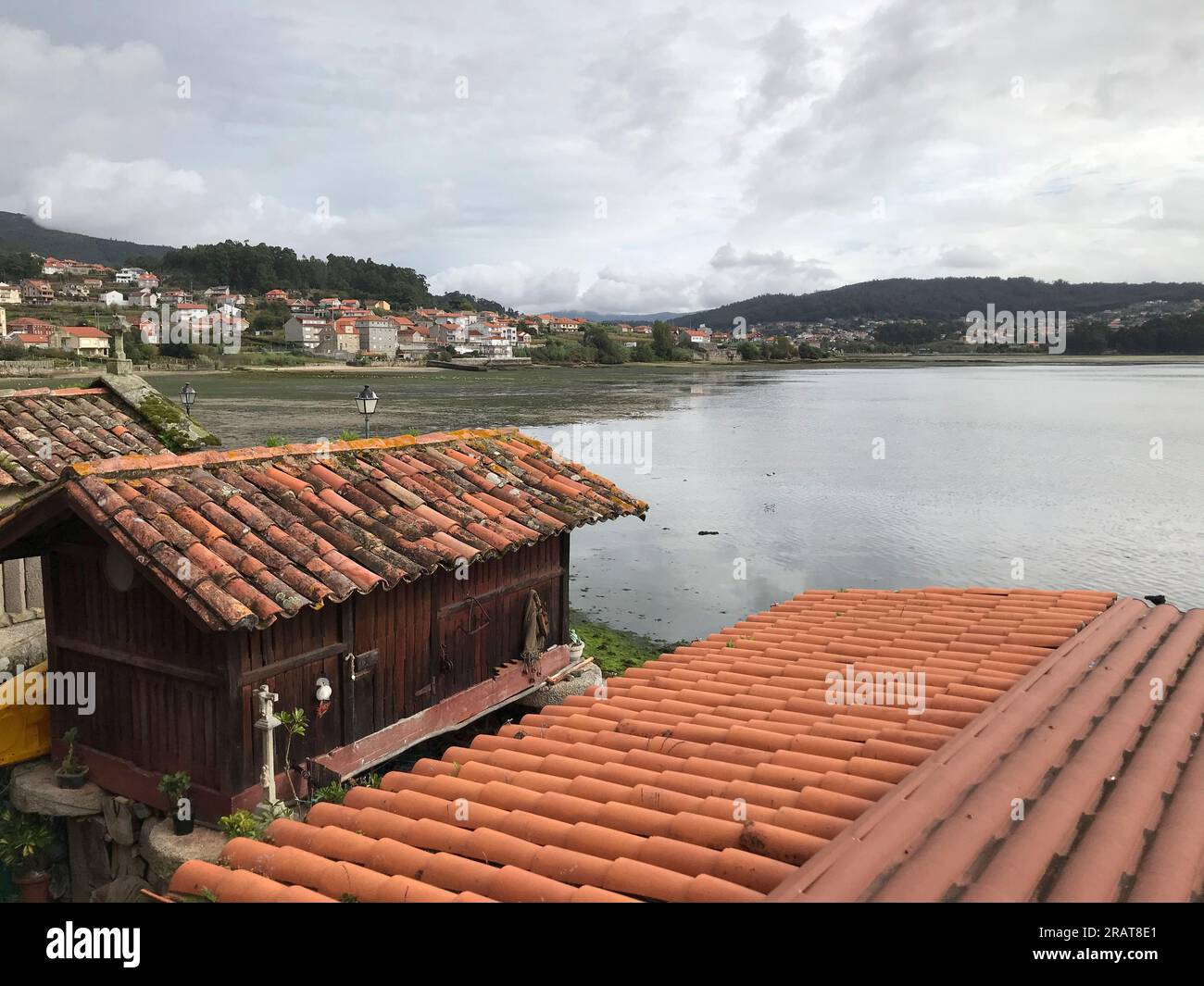 View of the horreo lined with wood and the Galician coast in the background. Stock Photo