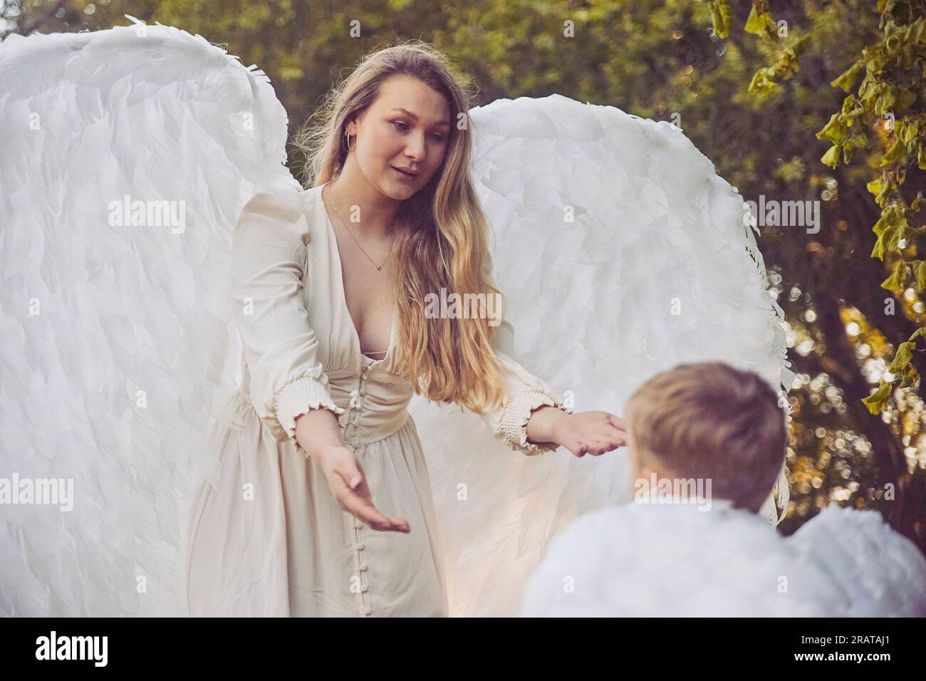Olstrup, Denmark, June 6, 2023: Girl angel with her son in the garden Stock Photo