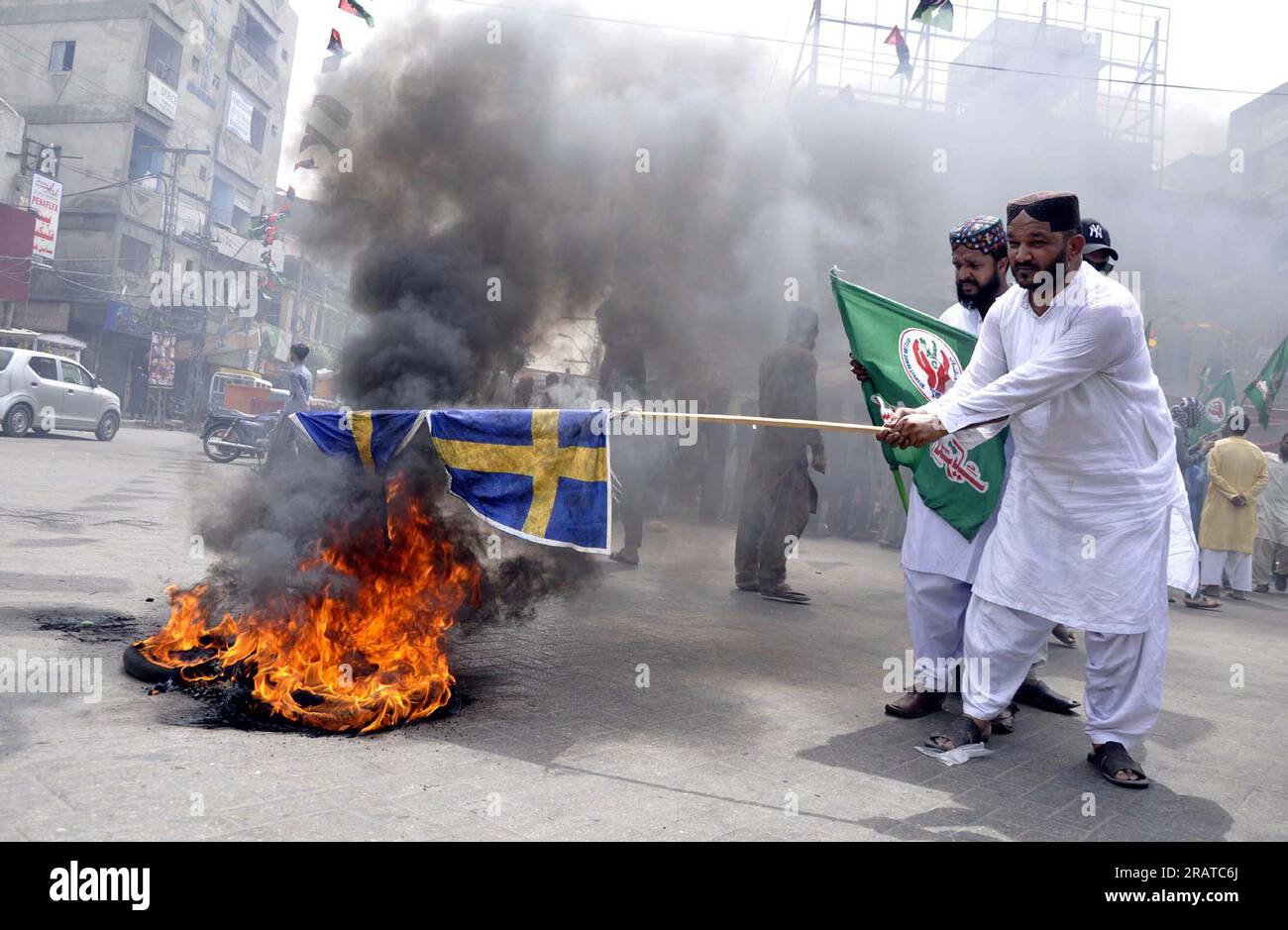 Activists of Sunni Tehreek (PST) are burn tires as they are holding protest demonstration against desecration of Holy Quran in Sweden, at Hyder Chowk in Hyderabad on Wednesday, July 5, 2023. Stock Photo