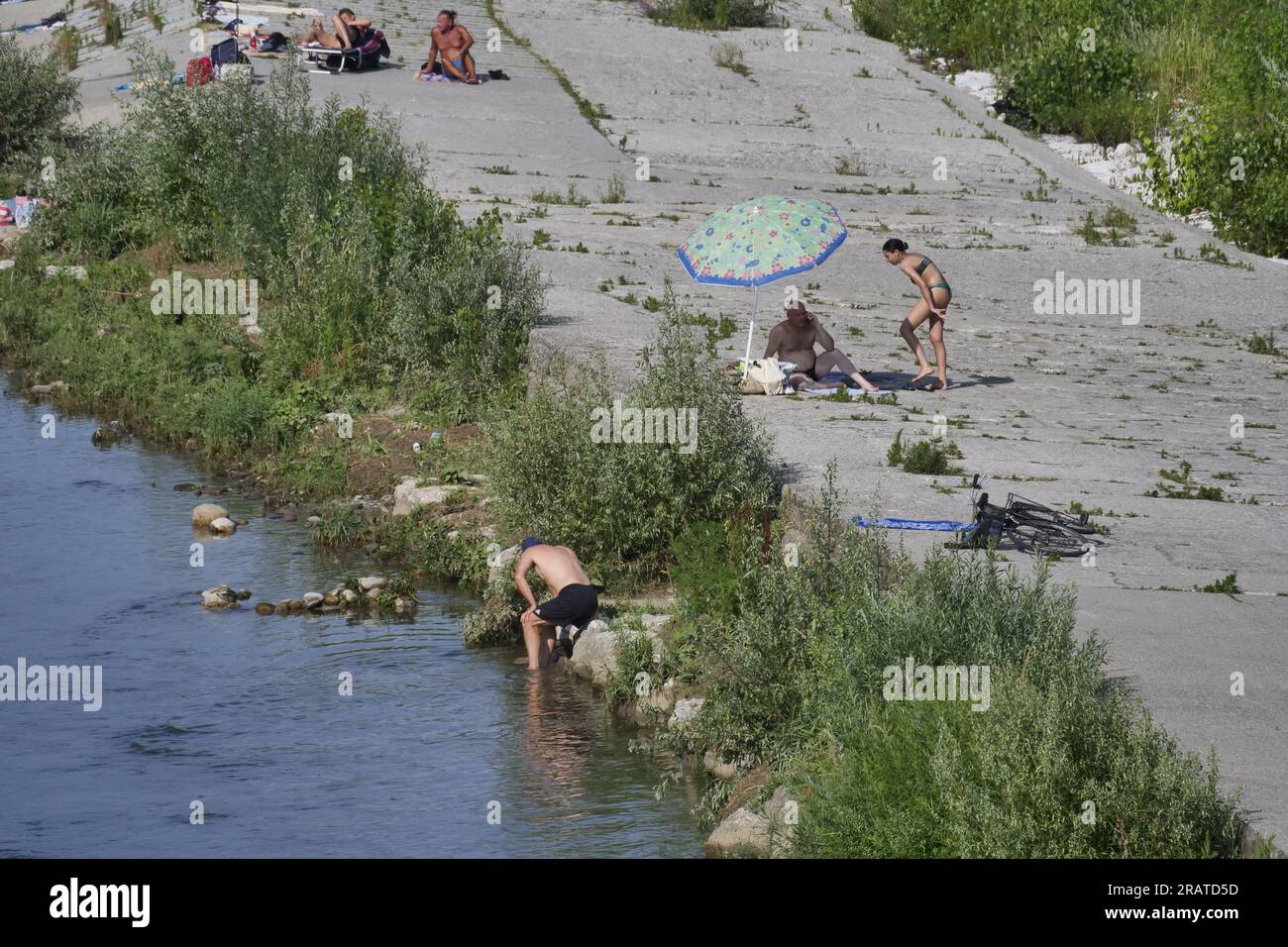 Along the Adda river, swollen by the last rains, many bathers, despite the prohibitions and the great danger, many enter to bathe. Stock Photo