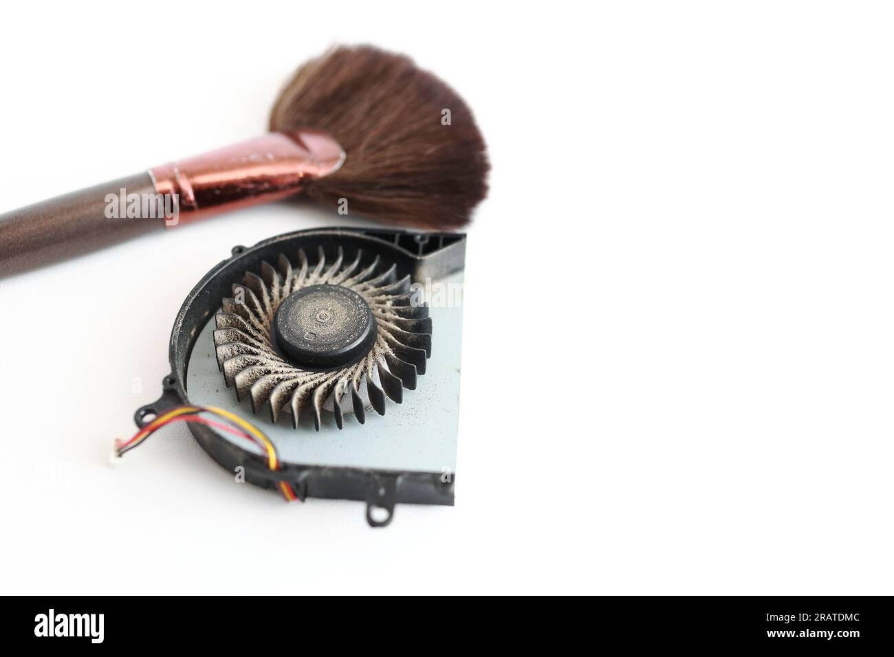 Cleaning brush and dusty laptop cooling fan on white background. Air