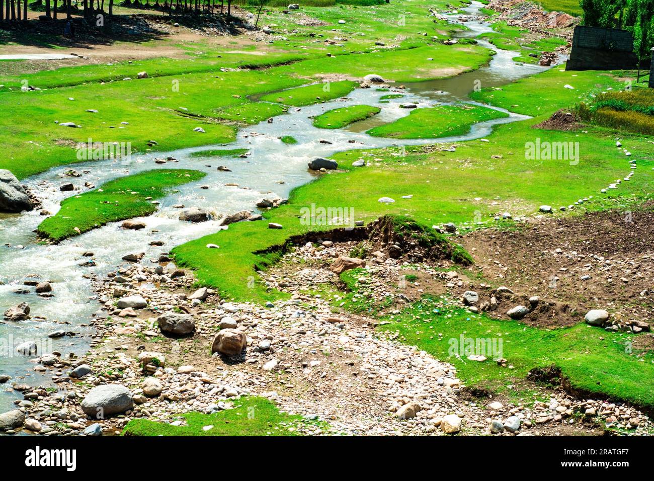 Lush green landscape and stream in the Hindu kush mountains range Stock Photo