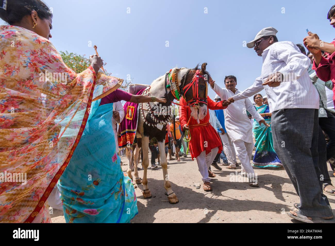 Wide shot of people touching head of horse to take blessings during palkhi festival Stock Photo