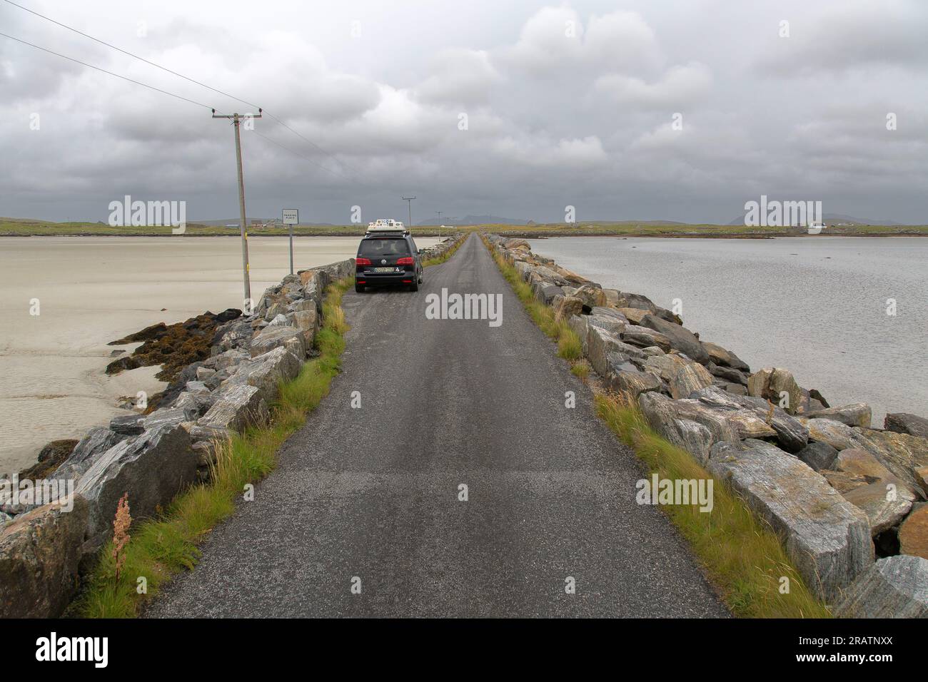 Travel Car with Roof Box cossing Oitir Mhor on Baleshare Causeway, Baleshare, Uist, North Uist, Hebrides, Outer Hebrides, Scotland, United Kingdom Stock Photo