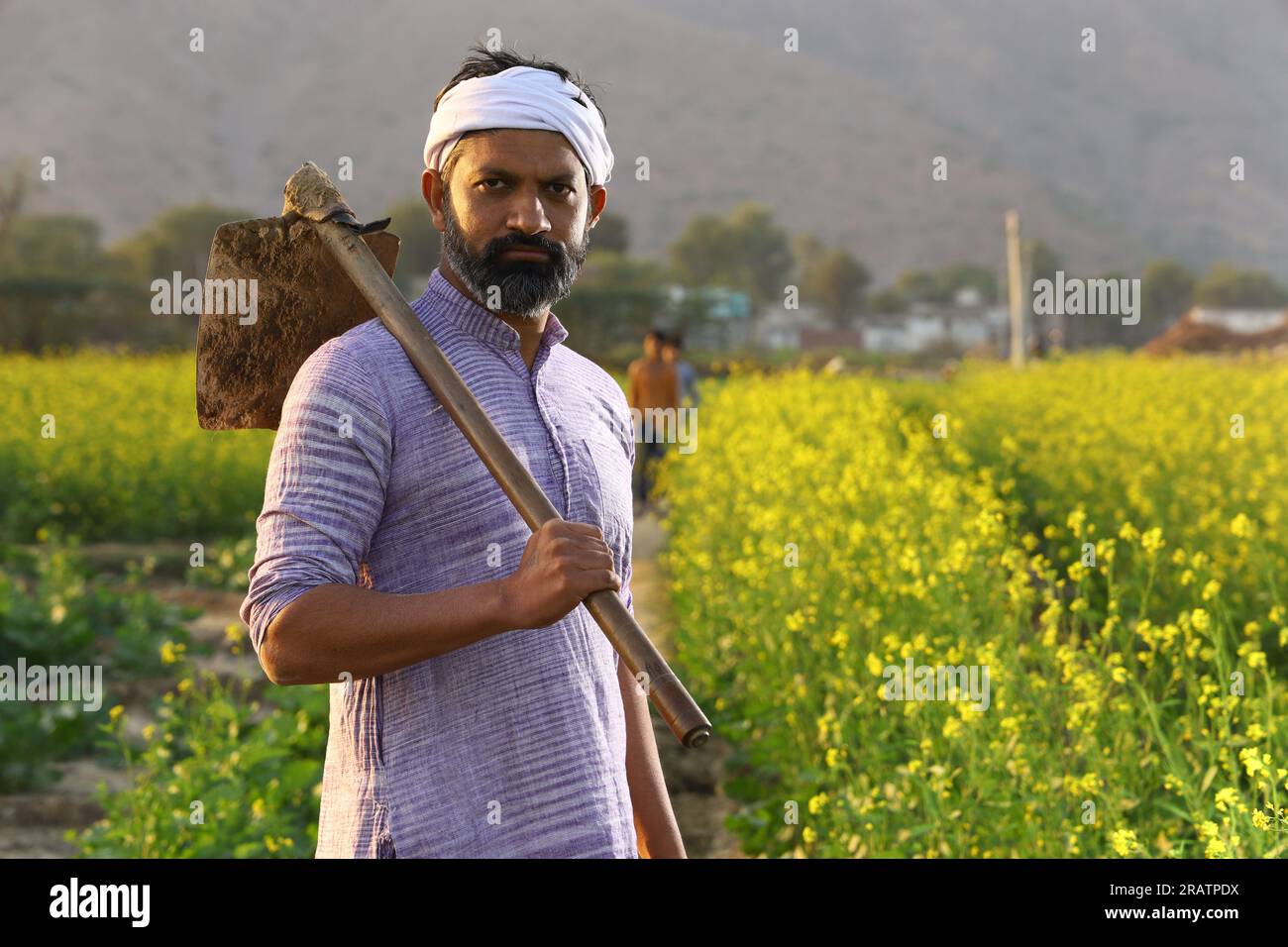 Angry bearded Indian farmer in turban standing with a shovel in his ...