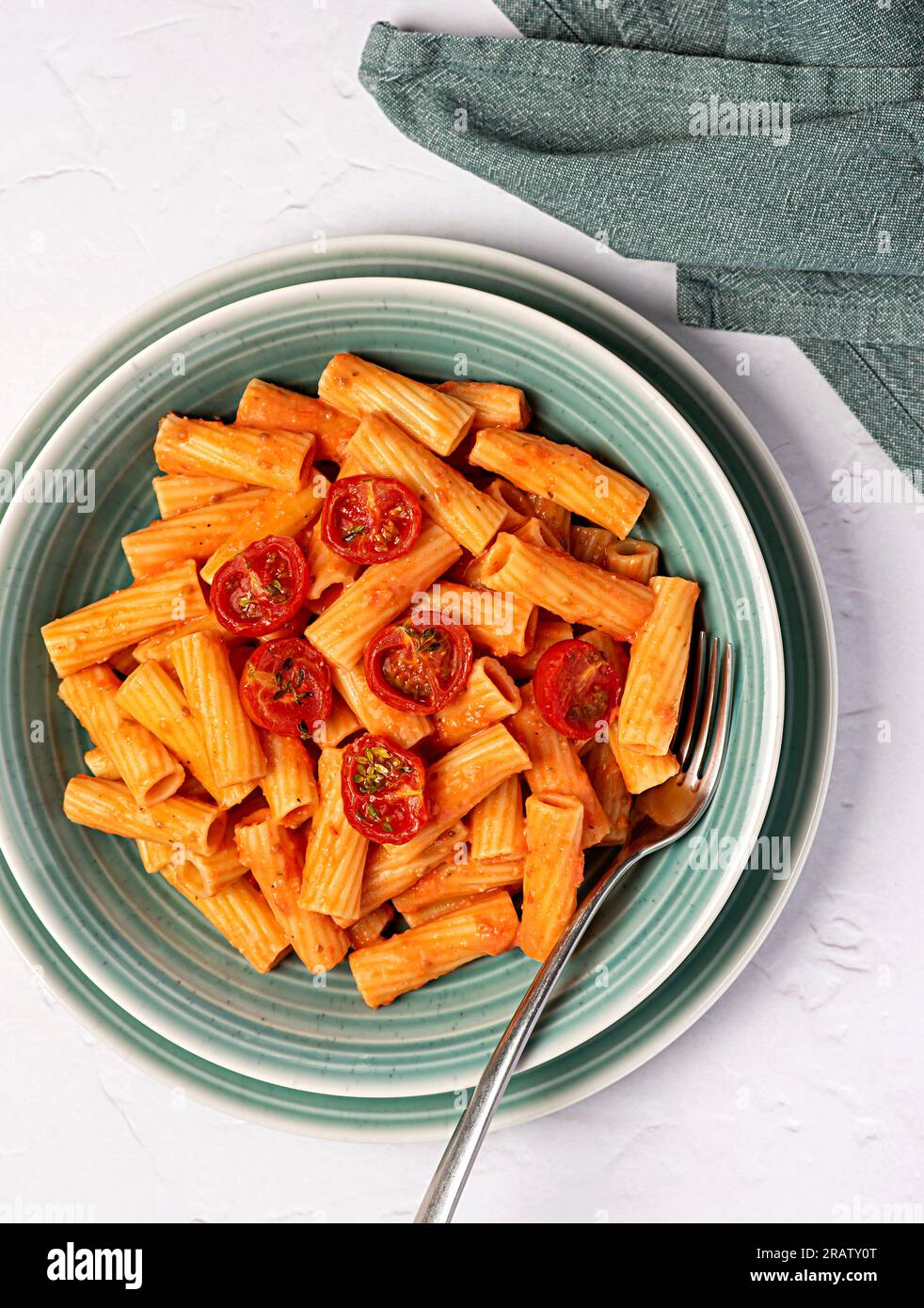 Food photography of pasta, rigatoni with  roasted tomatoes, sauce, olive oil, durum, wheat, semolina, fork, background, italian Stock Photo