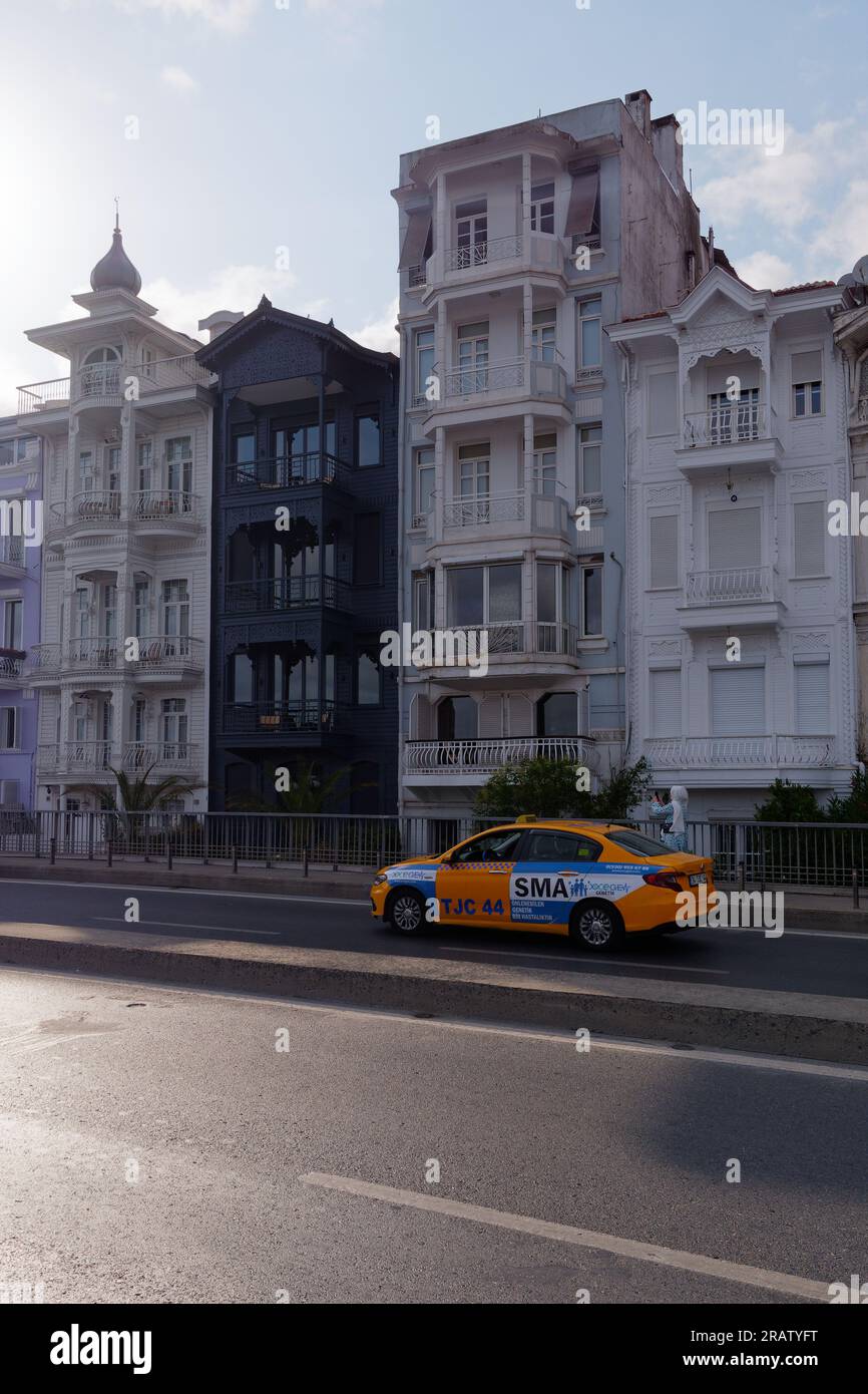 Yellow Taxi in front of quaint properties on a street in the neighbourhood of Bebek, Istanbul, Turkey Stock Photo