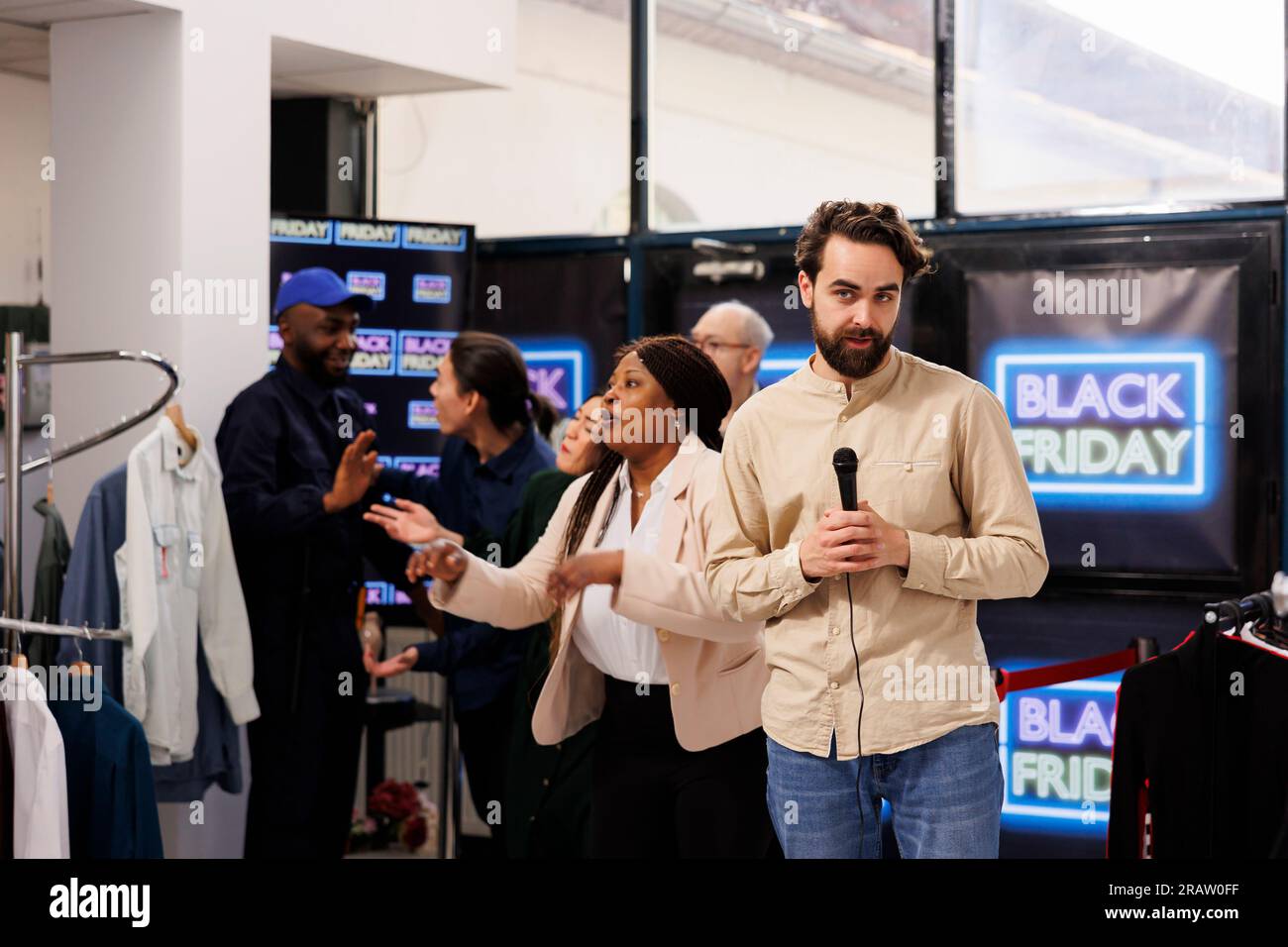 Excited happy crowd of shoppers rushing into clothing store to get best deals. Crazy frenzy diverse people running into shopping mall during Black Friday sales, hunting for bargains Stock Photo
