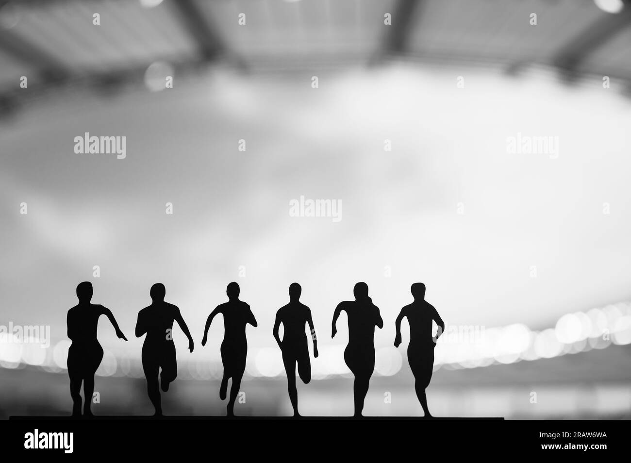 On the Fast Track: Silhouette of Six Sprinters Emerge in the Mesmerizing Evening Aura. Track and Field Summer Games 2024 in Paris Stock Photo