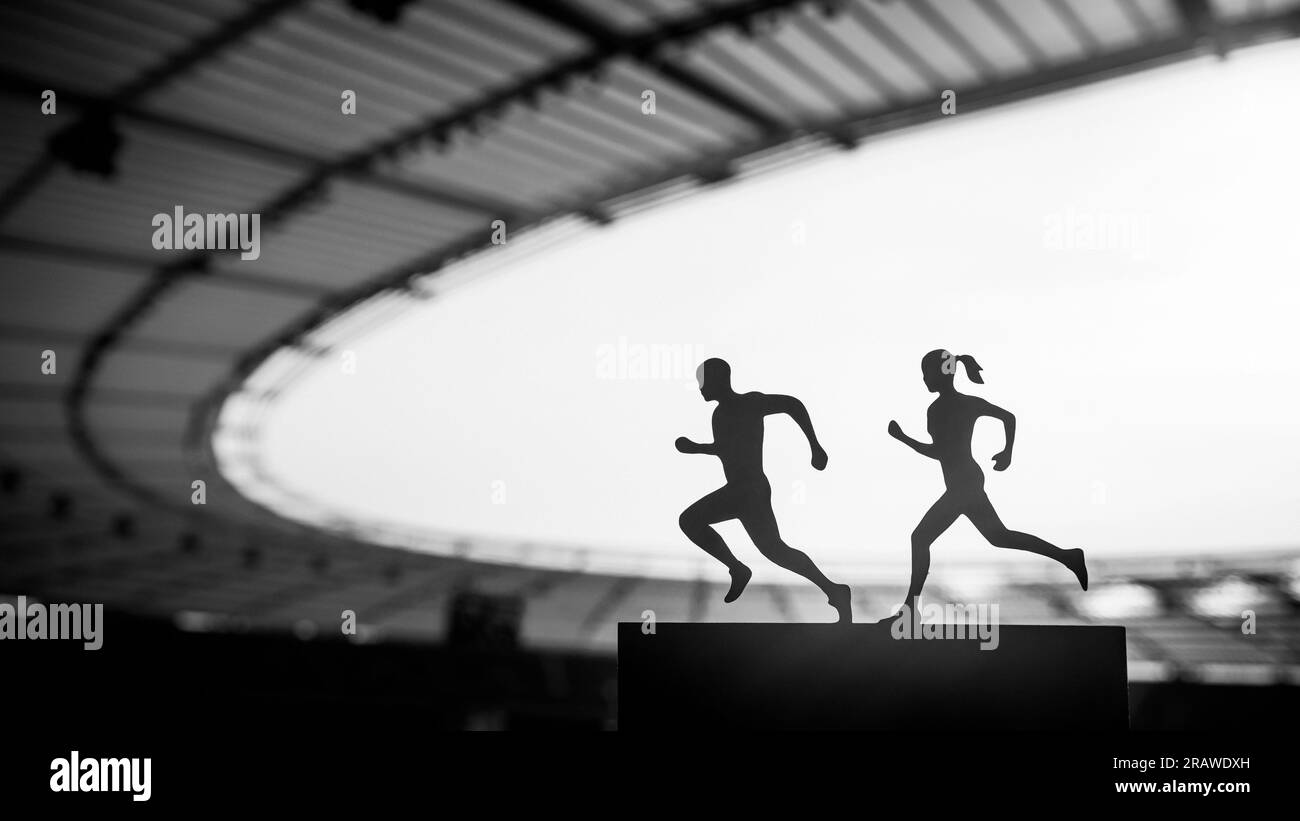 Shared Passion: Silhouettes of Male and Female Runners Create a Mesmerizing Display of Teamwork at a Modern Sports Stadium. Black and White photo, edi Stock Photo