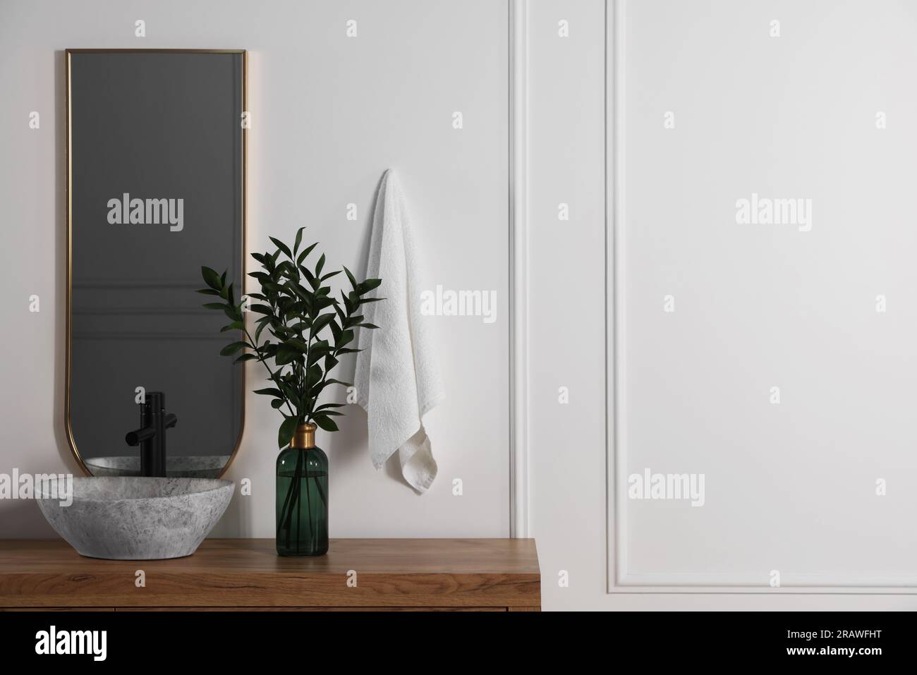 Stylish mirror over vessel sink and eucalyptus branches on bathroom ...