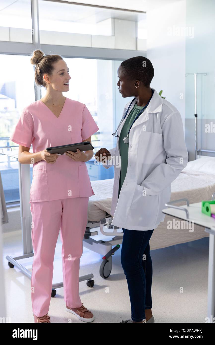 Unalt Diverse female doctors wearing medical uniforms using tablet and ...