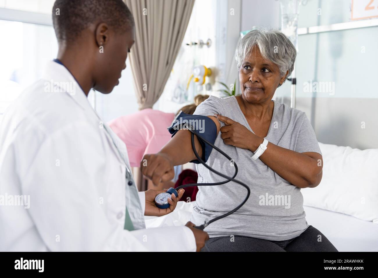 https://c8.alamy.com/comp/2RAWHKK/diverse-female-doctor-examining-senior-female-patient-measuring-blood-pressure-at-hospital-hospital-medicine-and-healthcare-services-unaltered-2RAWHKK.jpg