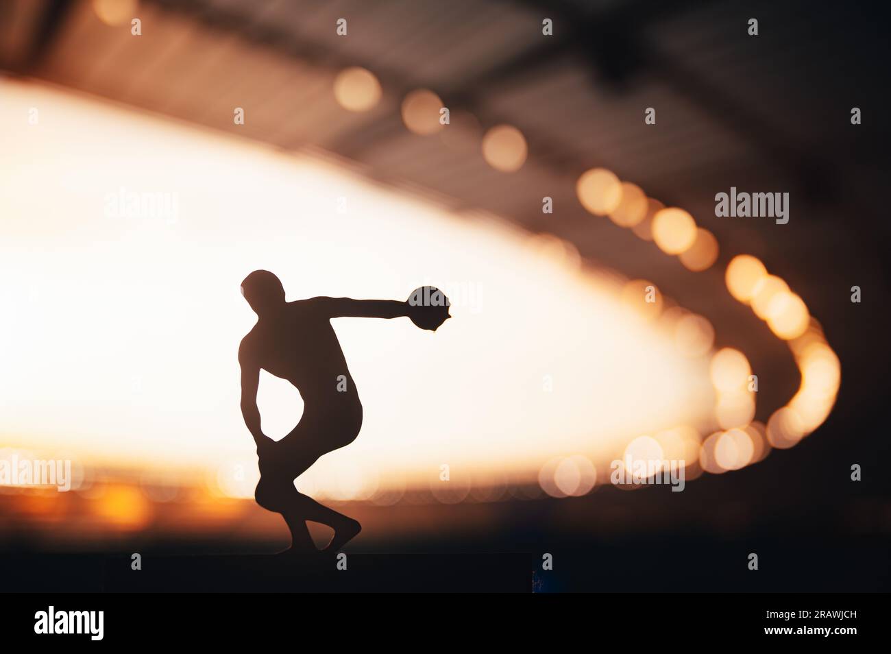 Silhouette of Athlete, Discus Soaring in the Breathtaking Evening Glow. Track and Field Photo for Summer Games in Paris. Stock Photo