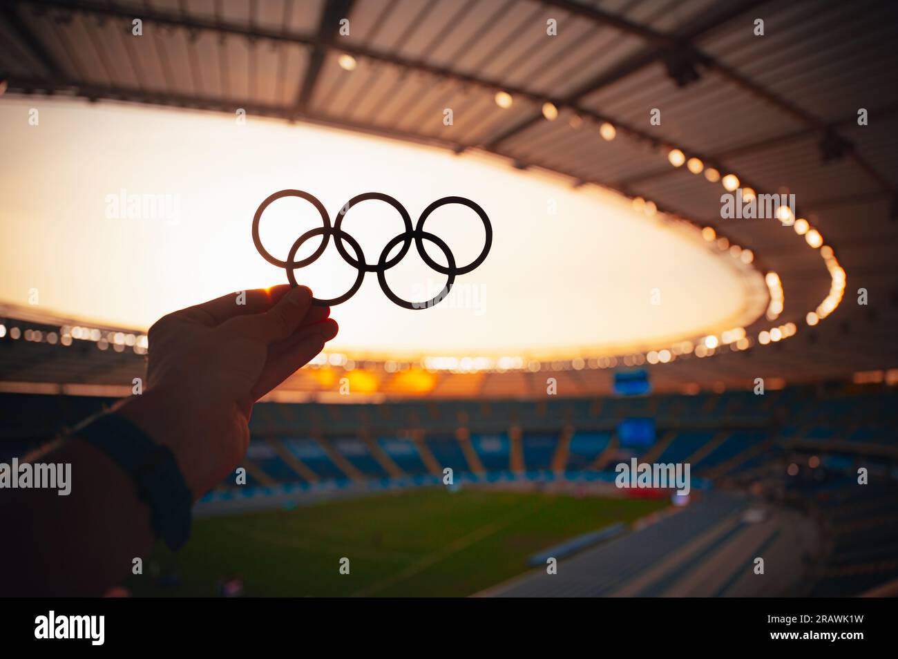 PARIS, FRANCE, JULY 7, 2023: Radiating Olympic Spirit: Athlete Showcases Olympic Rings in Serene Evening Light. Photo for Summer Olympic Games in Pari Stock Photo