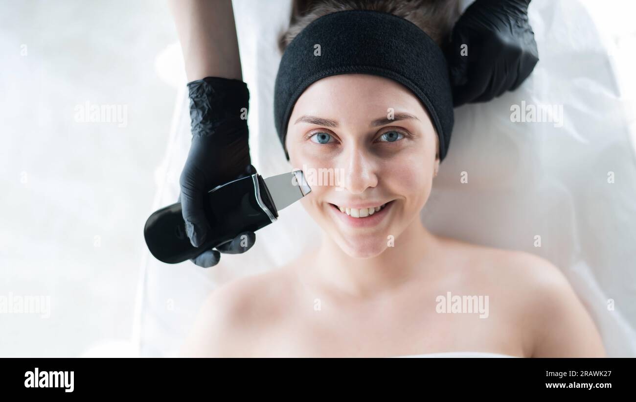 Woman on ultrasonic cleaning procedure. Hardware cosmetology Stock