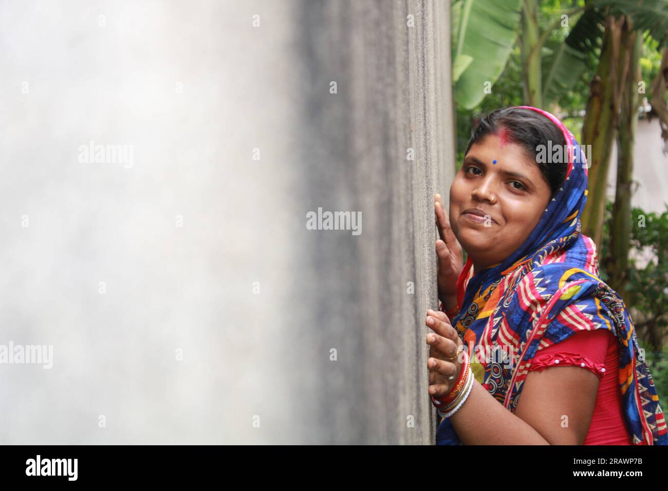 Young indian woman against a grunge wall, smiling and happy, being confident and friendly. Stock Photo
