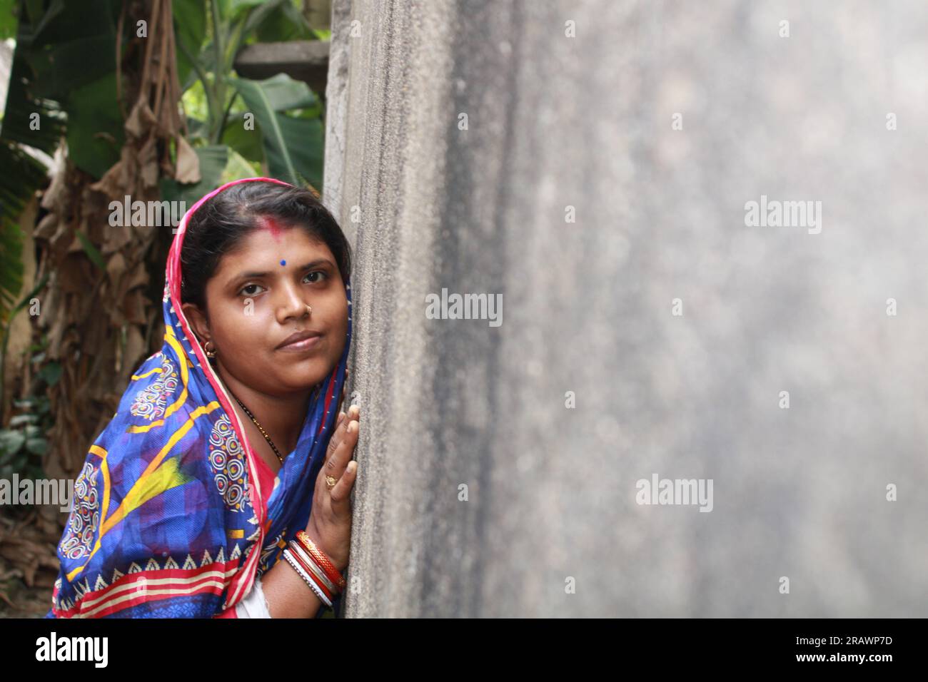 Young indian woman against a grunge wall, smiling and happy, being confident and friendly. Stock Photo