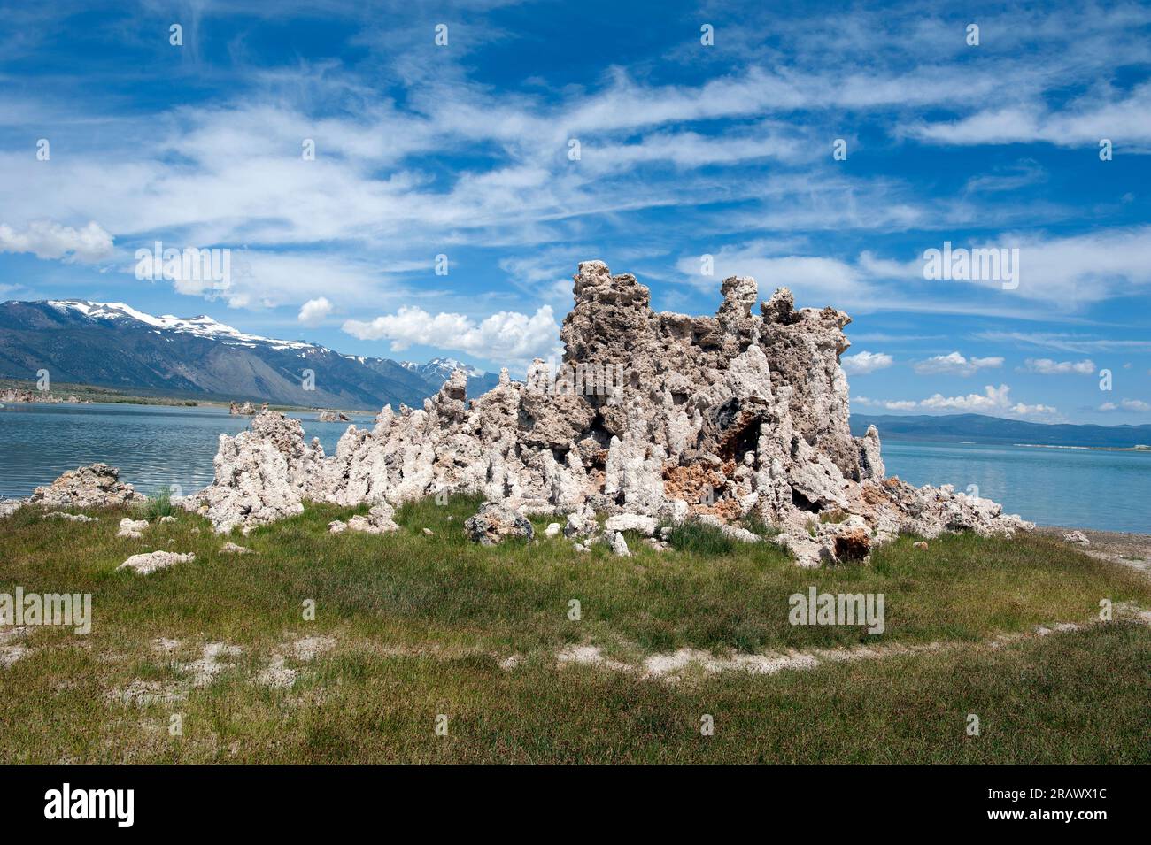 Tufas on land and receding water with Sierra Nevada mountains in background at Mono Lake, California, USA Stock Photo