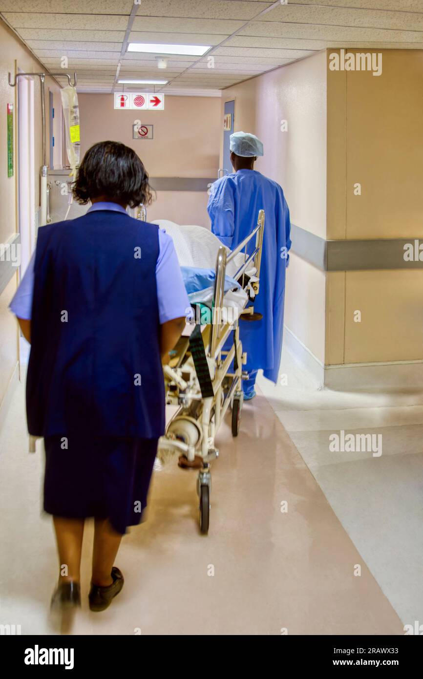 african medical facility nurse and doctor rushing a patient in a bed on ...