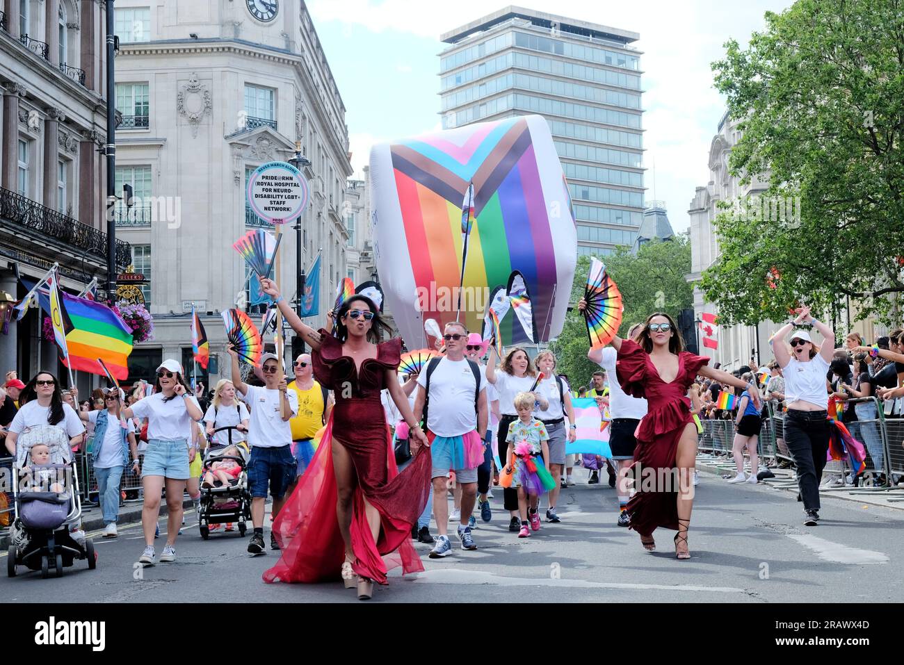 London, UK. Pride in London parade participants march with a giant inflatable with the LGBTQI+ flag printed on it. Stock Photo