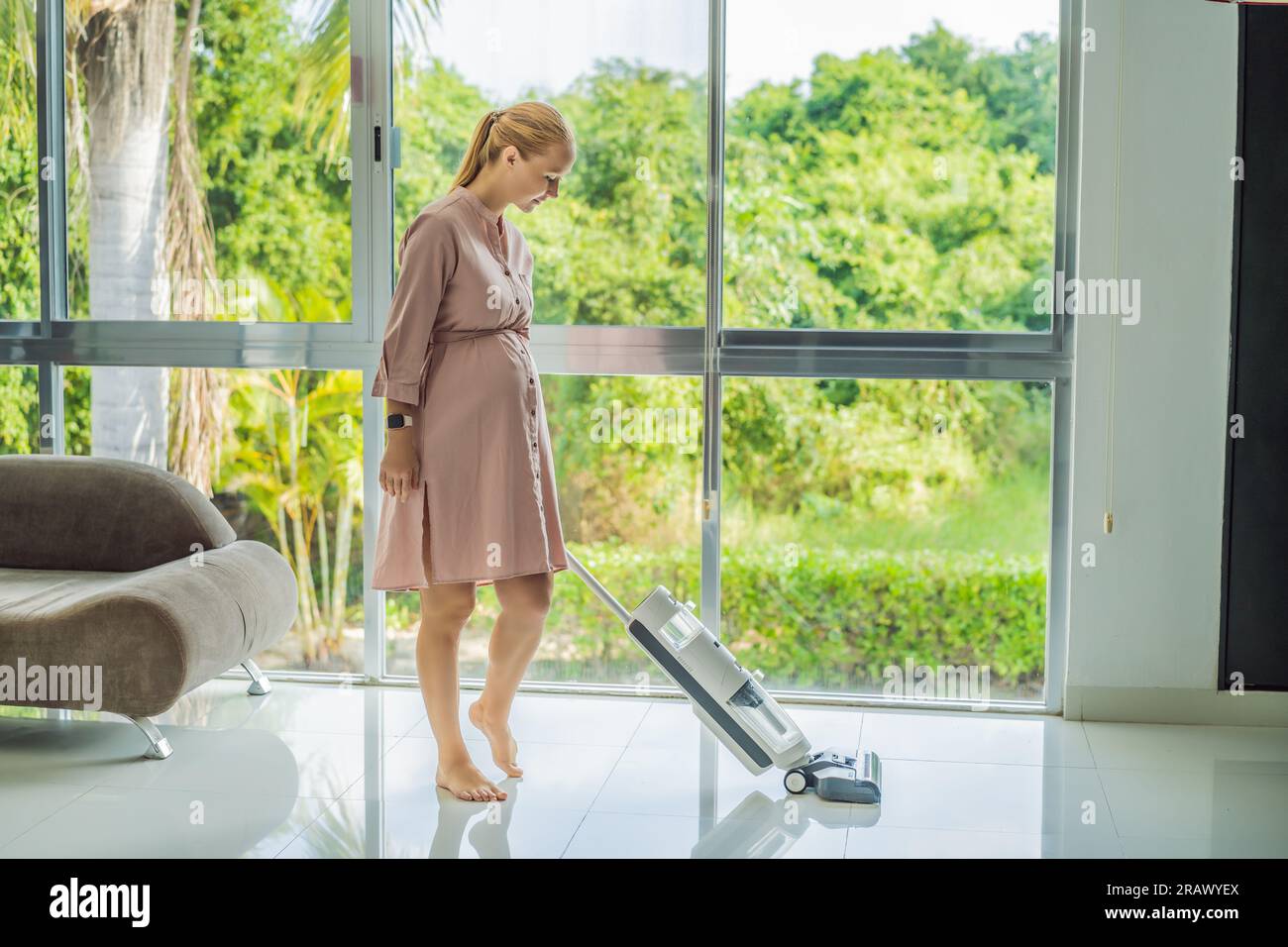 Young pregnant woman enjoys cleaning her house. Easy cleaning with a