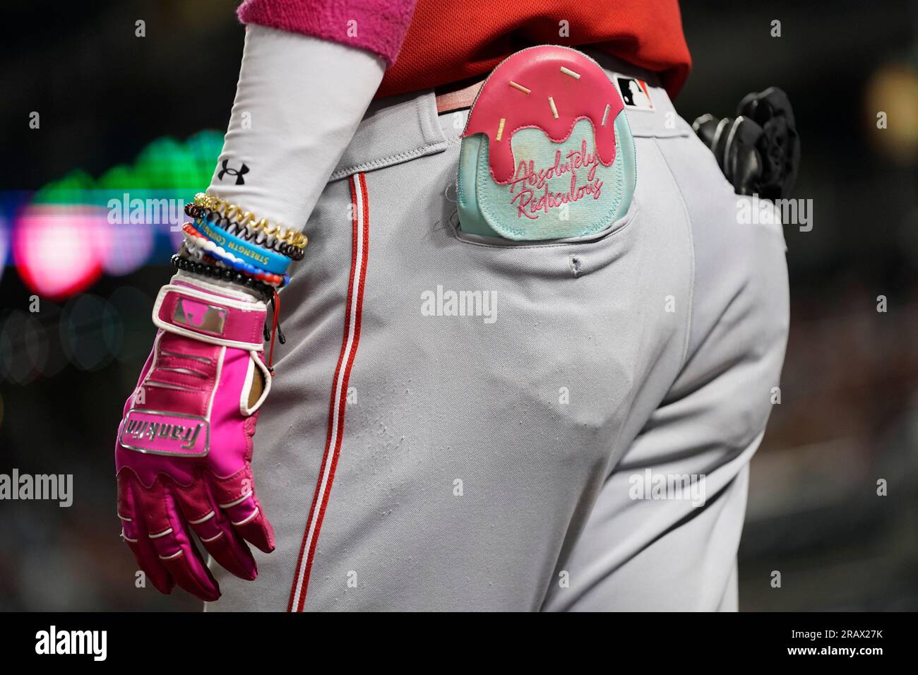 Cincinnati Reds' Elly De La Cruz carries a a sliding mitt in his back