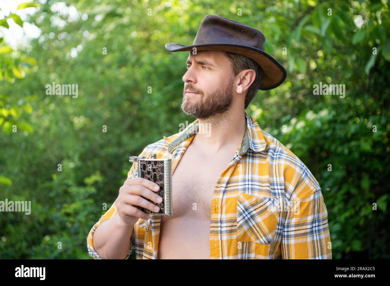masculine cowboy with flask outdoor. masculine cowboy with flask wear ...