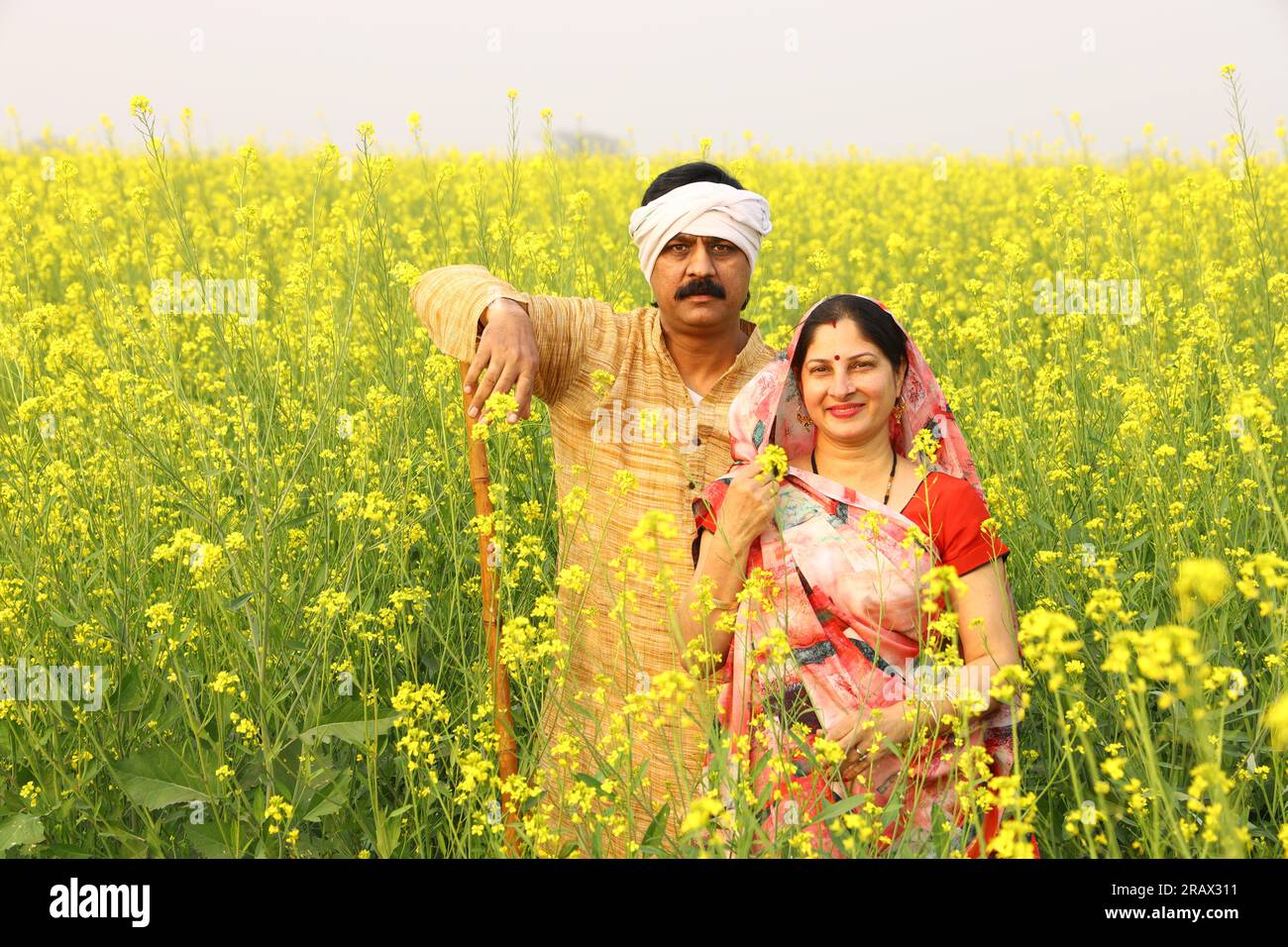 Happy rural Indian family standing in a mustard field. Happy to see the ...
