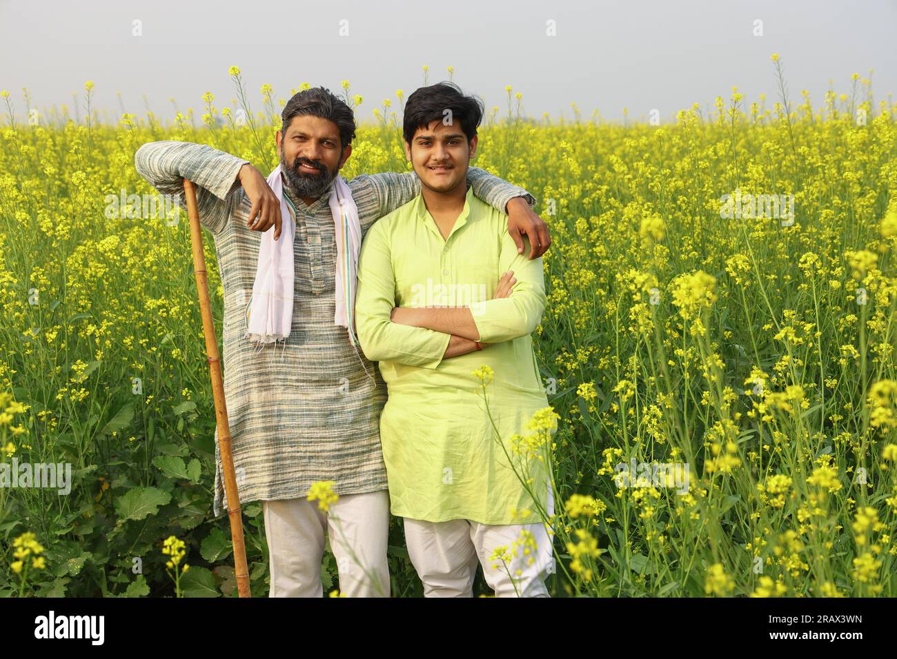 Happy rural Indian men standing in a mustard field Stock Photo
