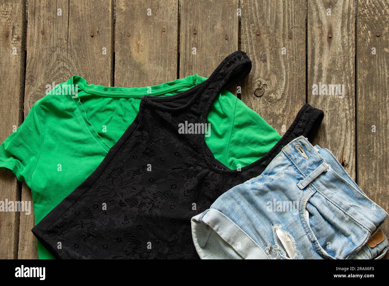 women's clothing shorts and t-shirts green and black on a wooden background close-up, women's clothing Stock Photo