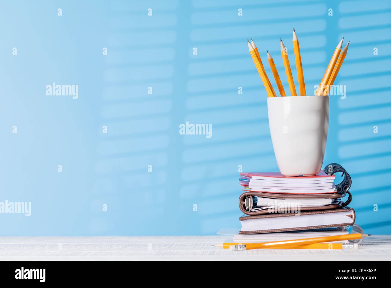 An organized arrangement of pencils and notepads on an office desk ...
