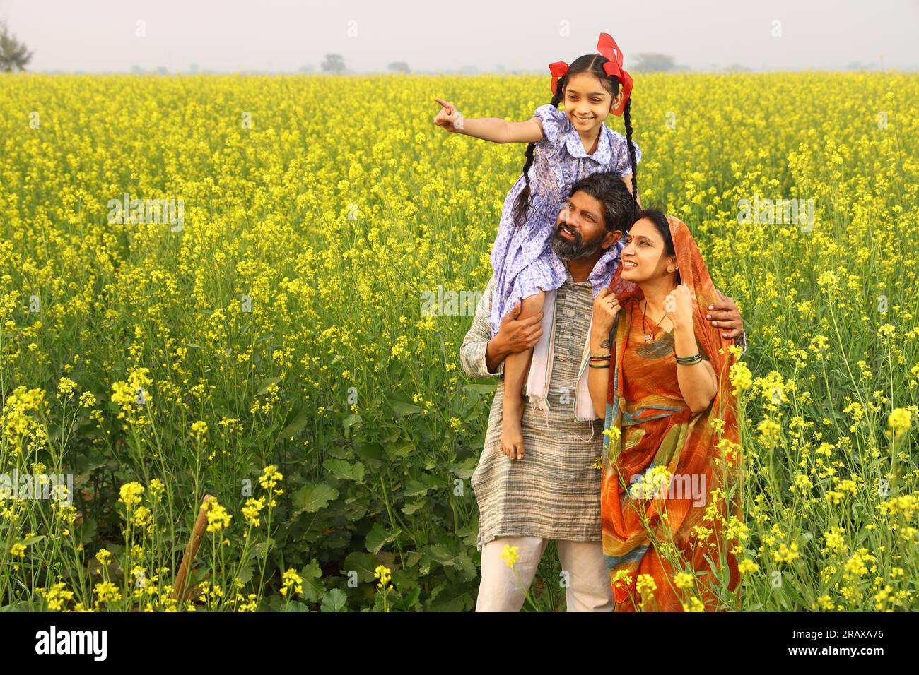 Farmer with daughter standing in mustard field hi-res stock photography ...