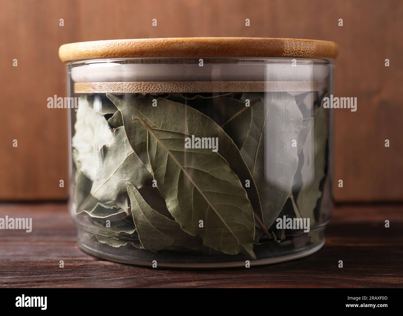 Bay leaves in glass jar on wooden table Stock Photo