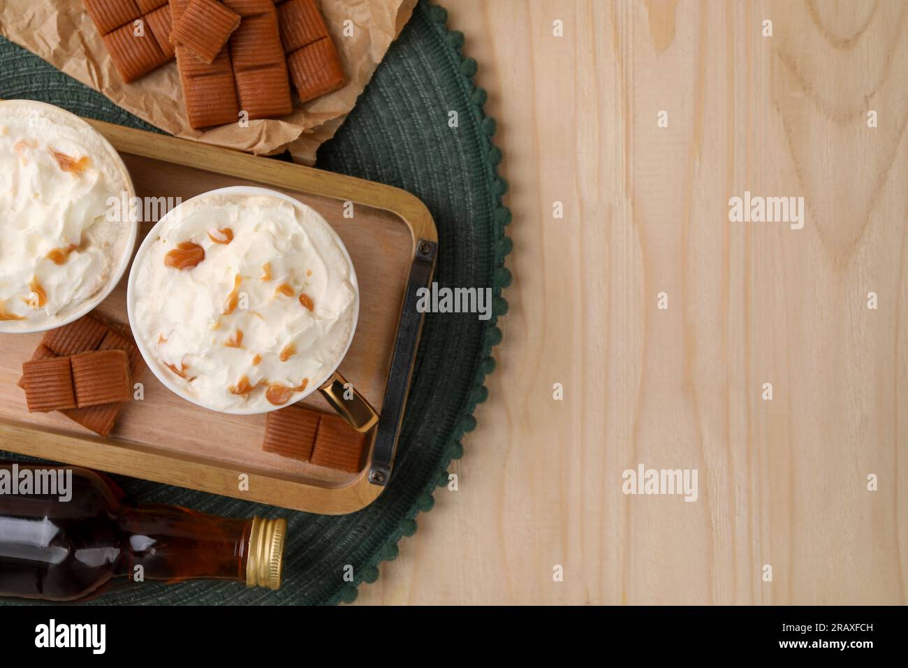 Delicious coffee with whipped cream and caramel syrup on wooden table ...