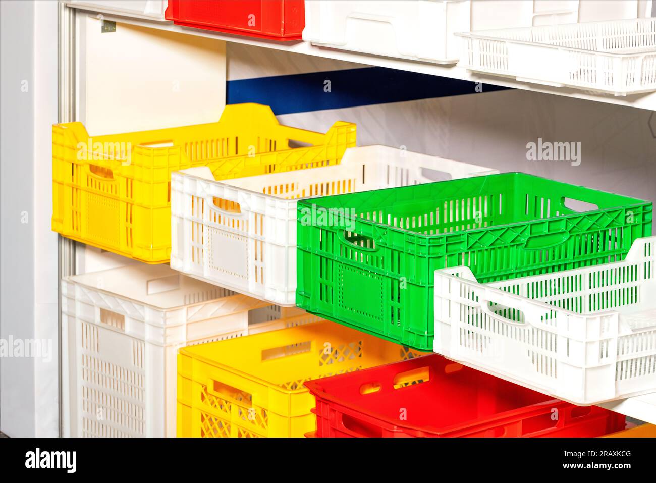 Plastic colored boxes on racks for storing various products. Stock Photo
