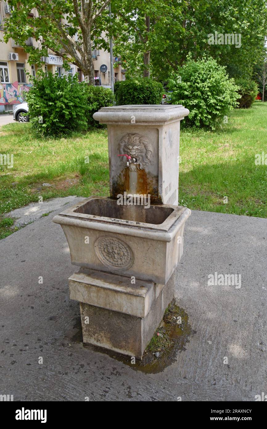 An ornate stone public drinking fountain in the city street of Podgorica, Montenegro Stock Photo