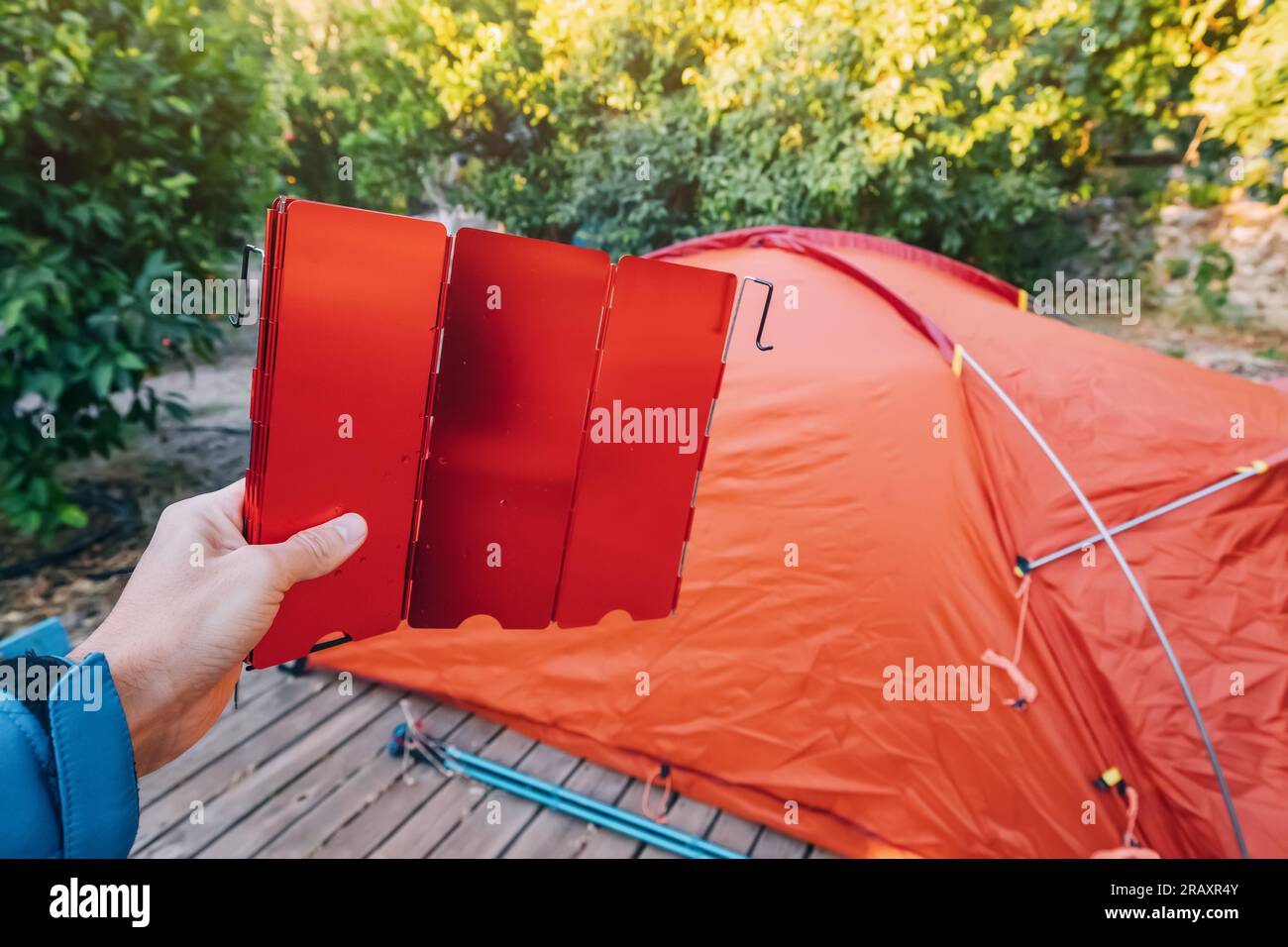 Assembling and installing a tent in a camping. Wind shield for burner in hand. Equipment and materials for hiking Stock Photo