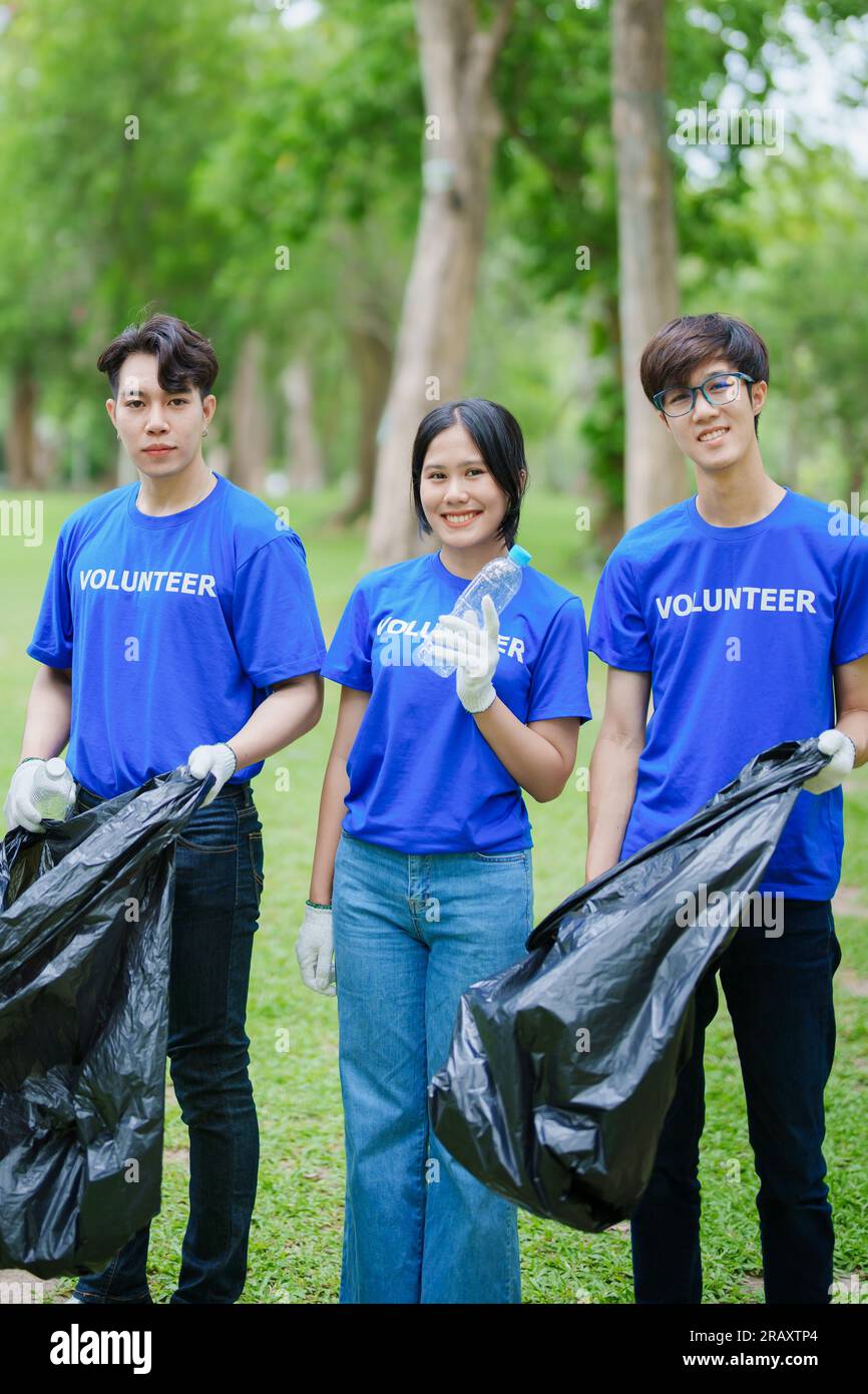 Multiethnic volunteers donate their time holding black garbage bags to
