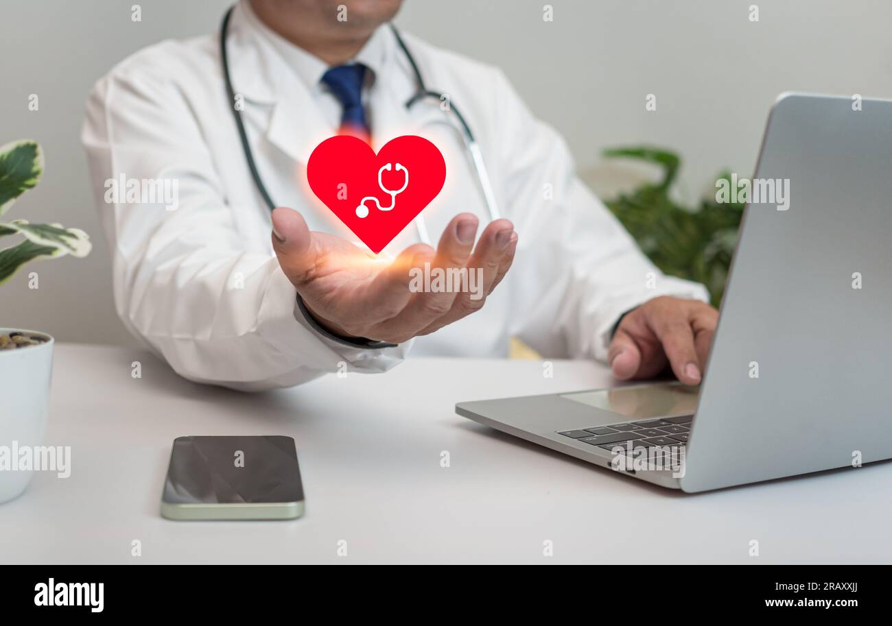 A Doctor holding and showing a red heart at hospital office. Medical ...