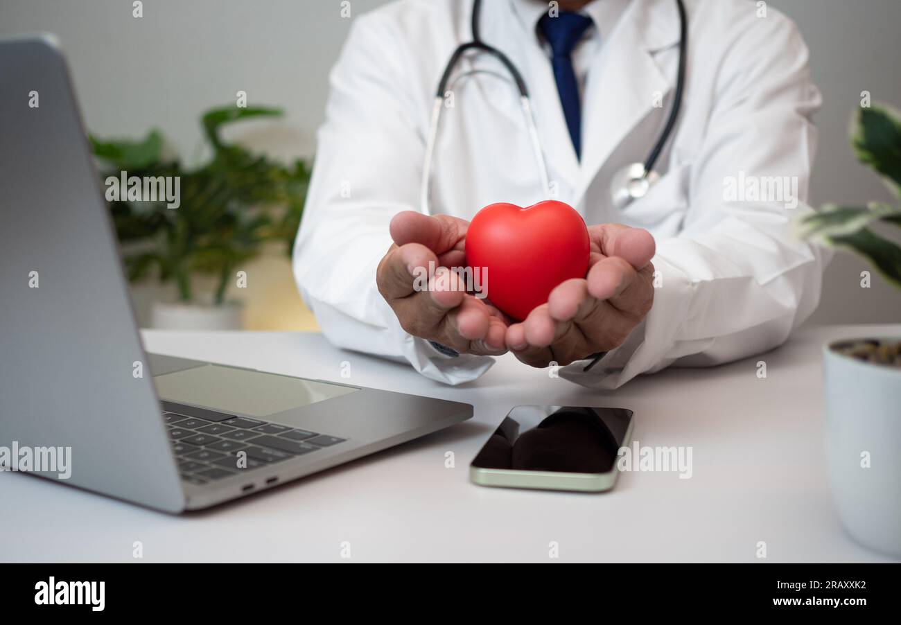A Doctor holding and showing a red heart at hospital office. Medical ...