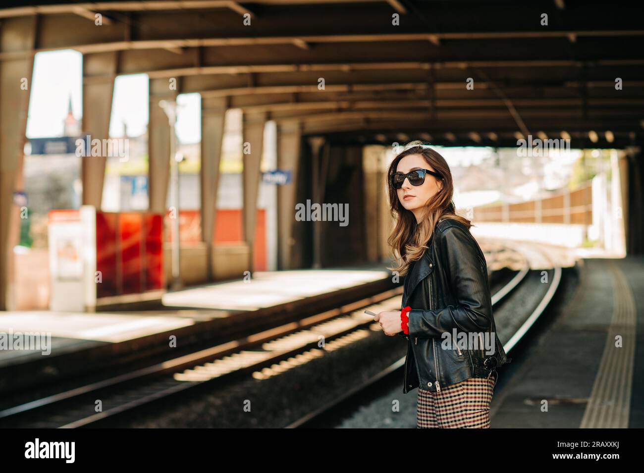 Young woman waiting for the train on a train station Stock Photo