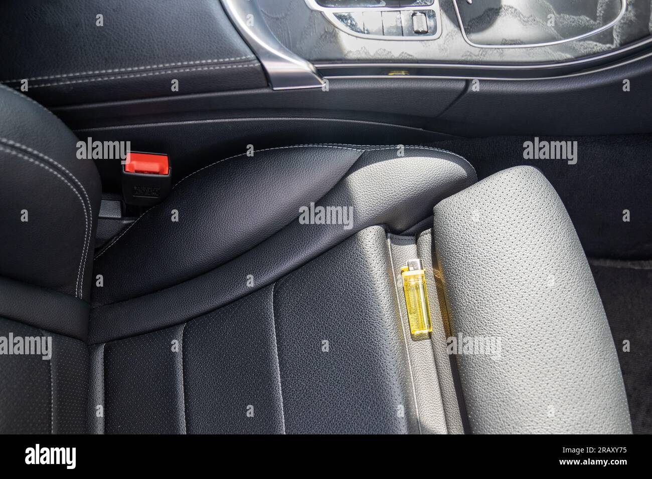 Forgotten gas lighter in car on seat, which can lead to fire in sunny hot weather. Stock Photo