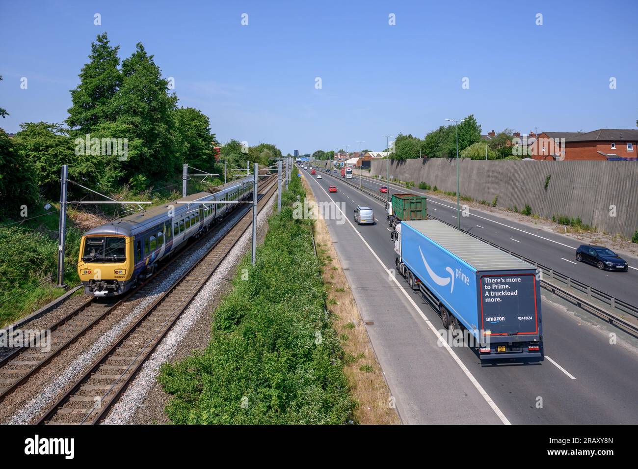 CLass 323 in Northern trains livery travelling on track running alongside a road in Salford, England. Stock Photo
