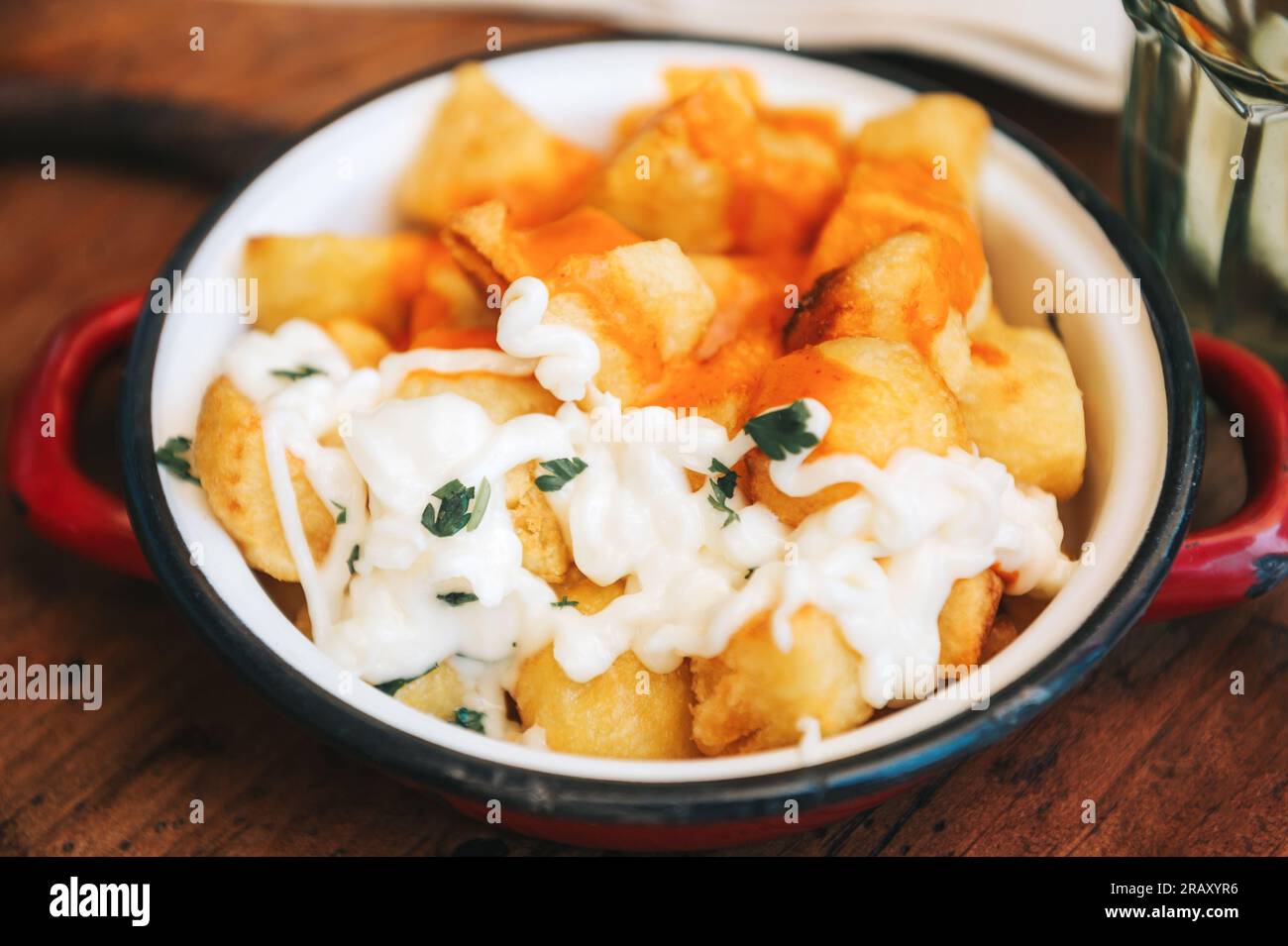 Famous Spanish Tapas Patatas Bravas served with spicy tomatoe sauce and