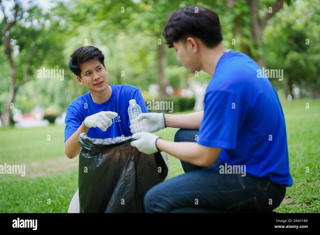 Multiethnic volunteers donate their time holding black garbage bags to