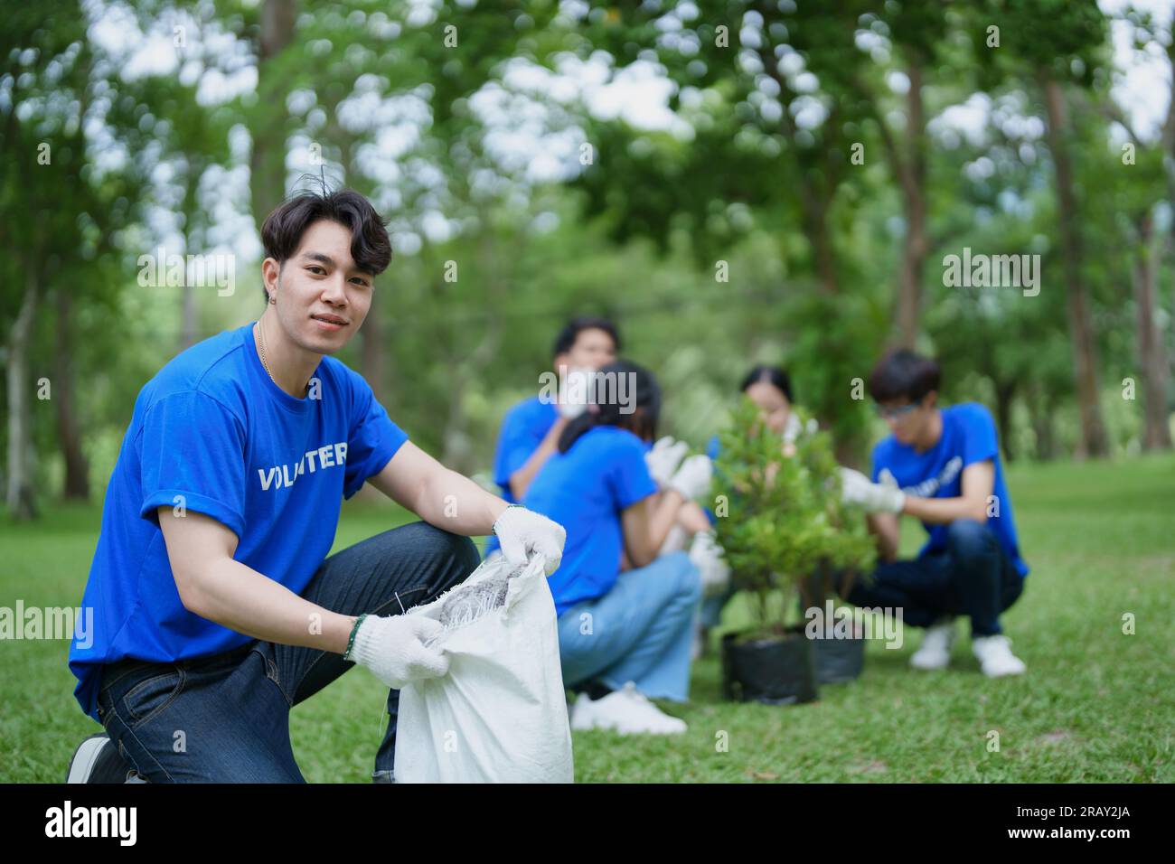 Volunteers of various nationalities are showing solidarity by sacrificing their personal time by planting trees to restore nature to reduce carbon Stock Photo